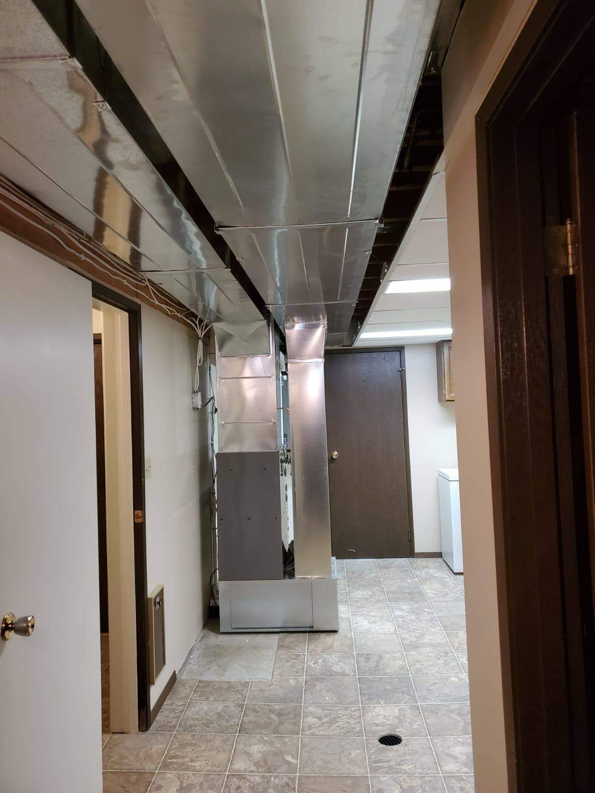 a long hallway with a stainless steel ceiling and a few doors .