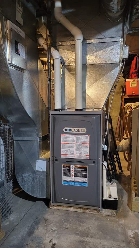 a furnace is sitting in the corner of a room in a basement .