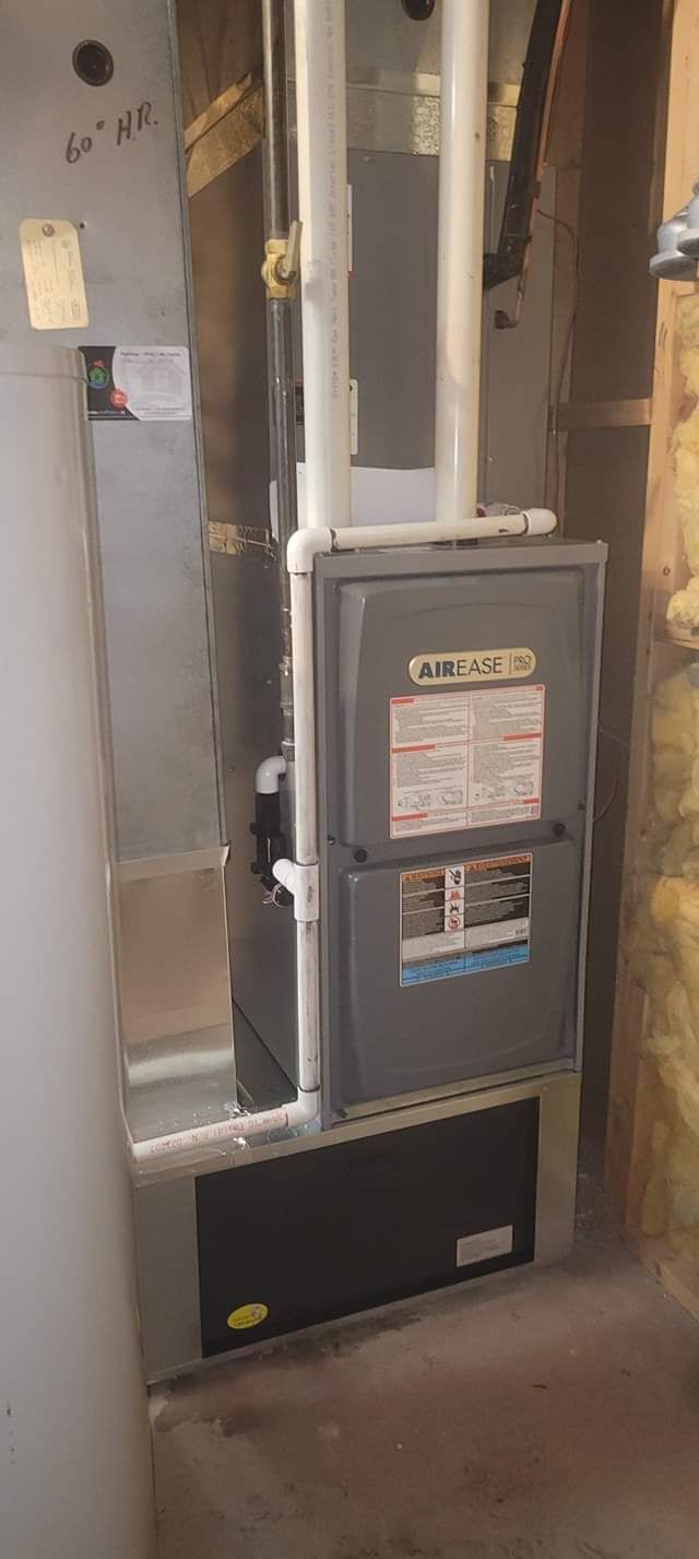 a furnace is sitting in a room next to a wall .