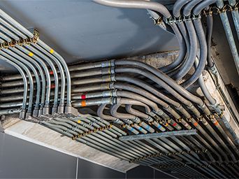 A bunch of pipes are hanging from the ceiling of a building.
