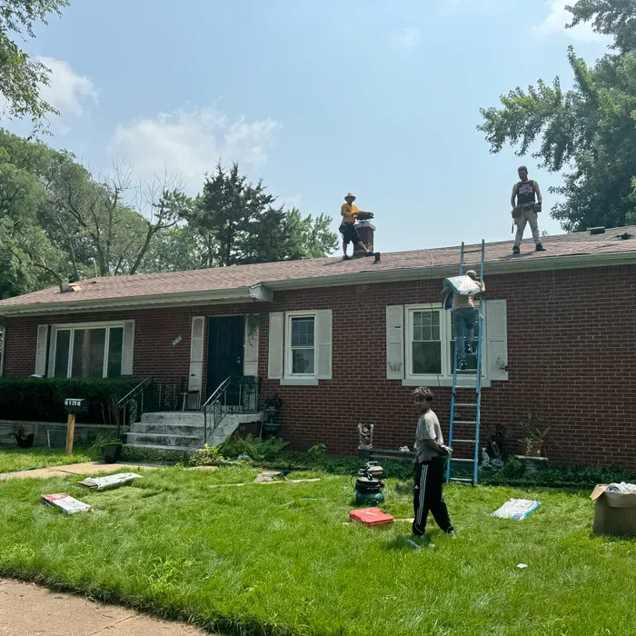 Dormer window with white trim, set in a slate shingle roof.