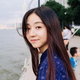 A woman with long hair is standing next to a body of water