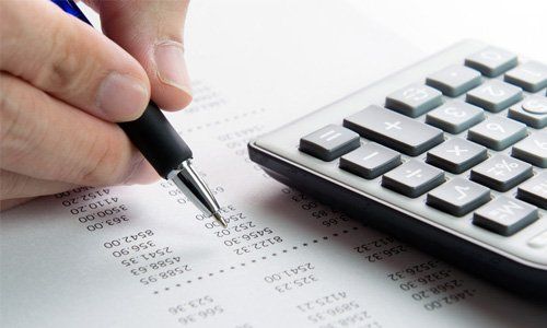 a person calculating tax using calculator