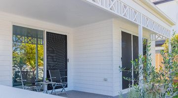 A white house with a porch and sliding glass doors.