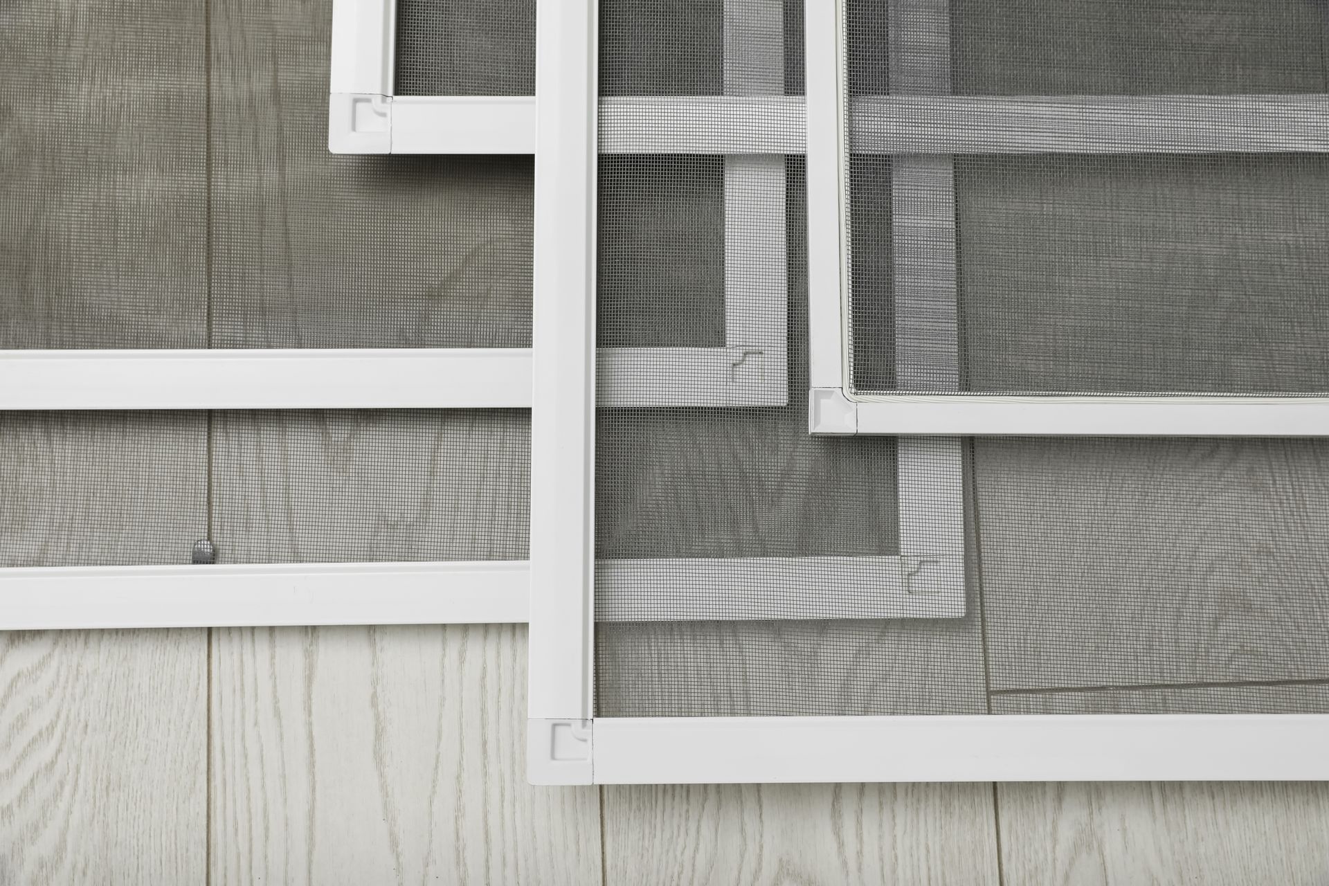 Set of window screens on wooden floor