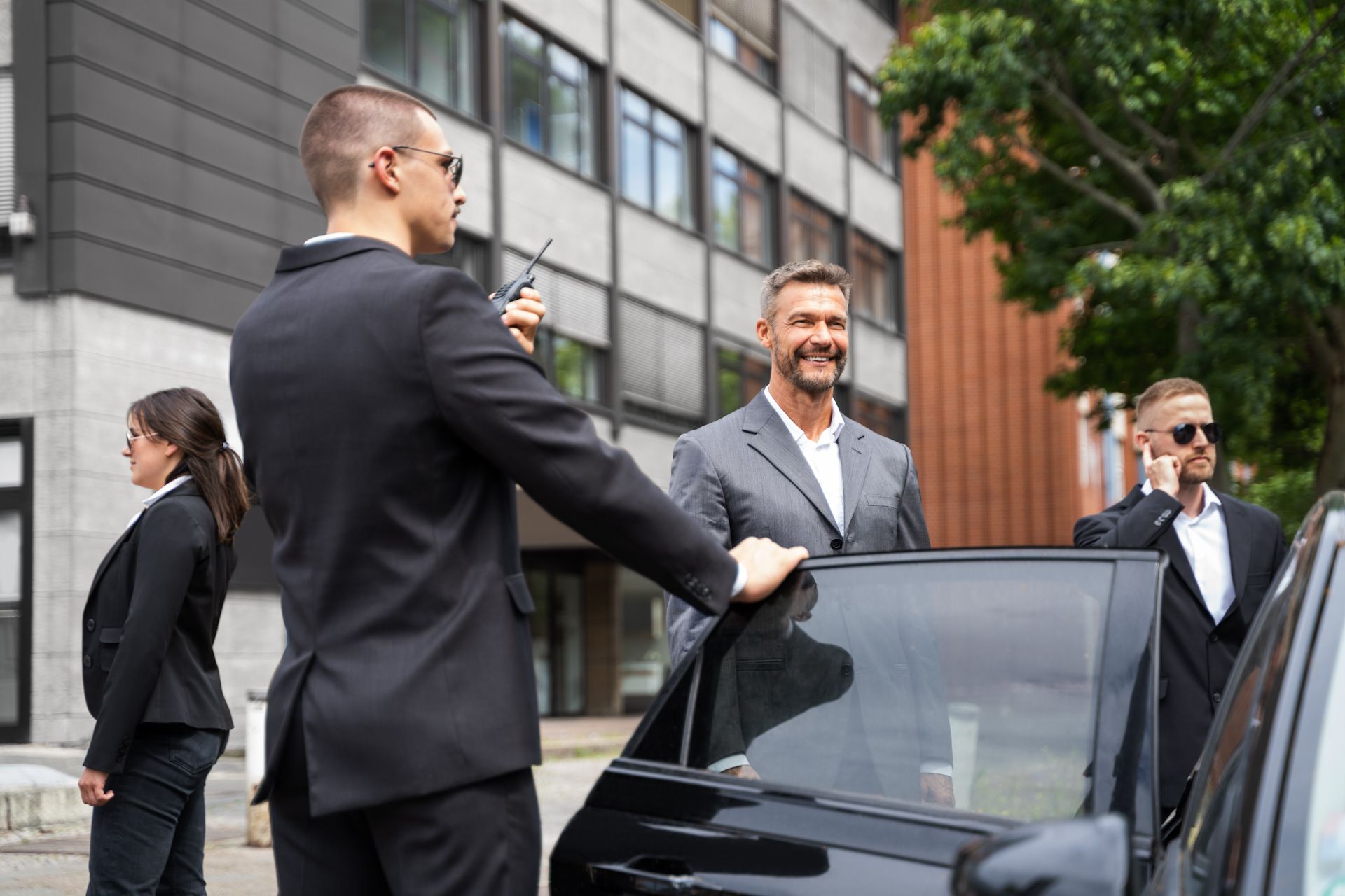 A man in a suit is getting out of a car.