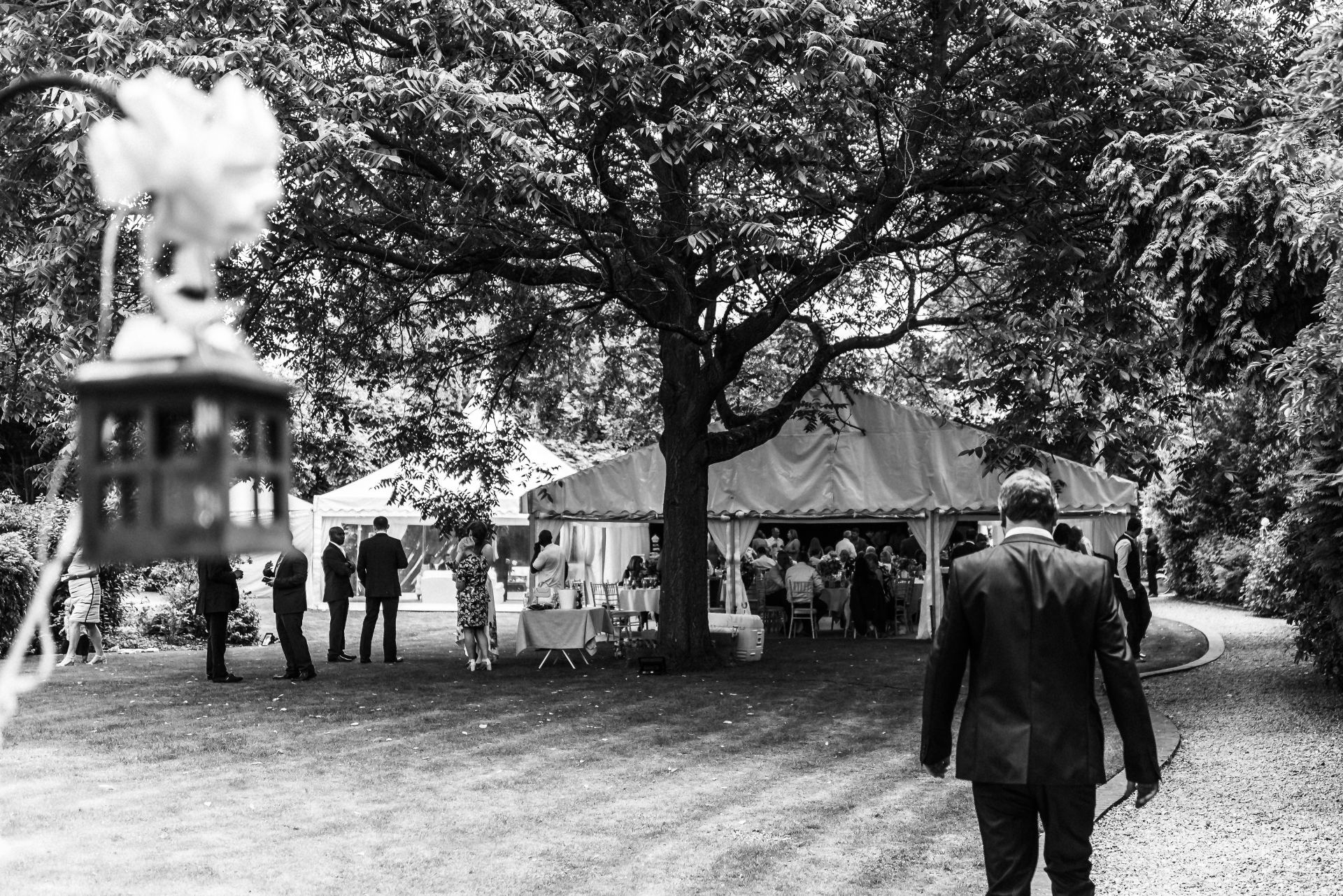 A black and white photo of a man walking in a park