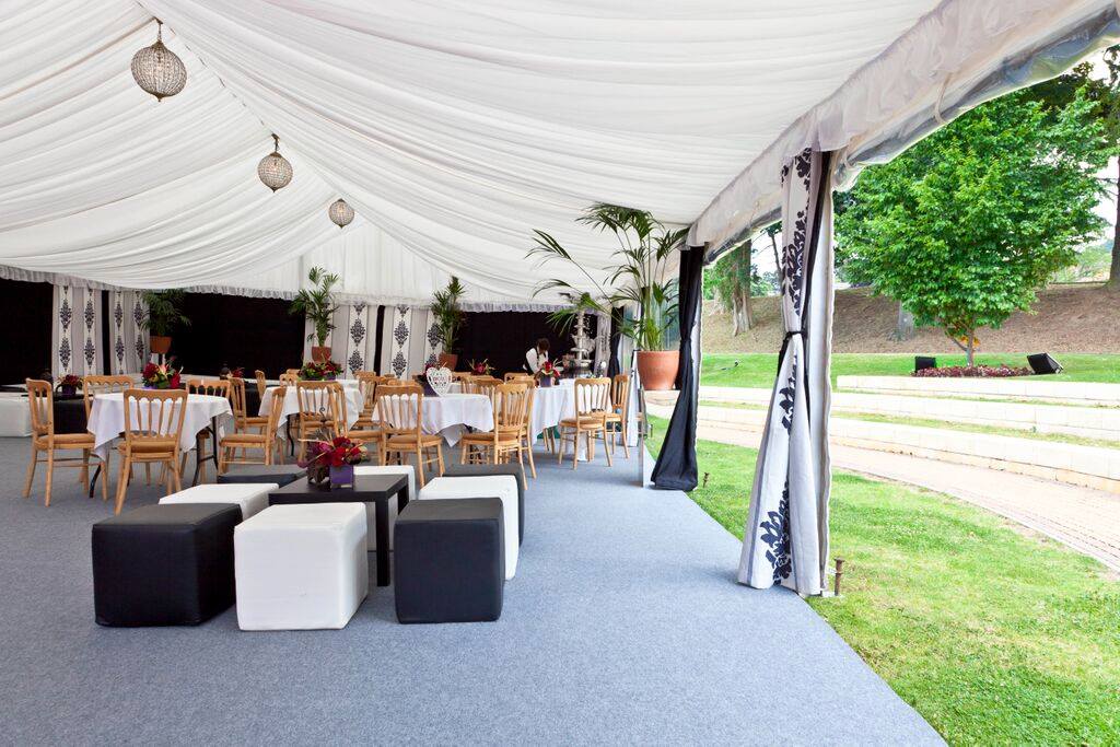 A large tent with tables and chairs underneath it