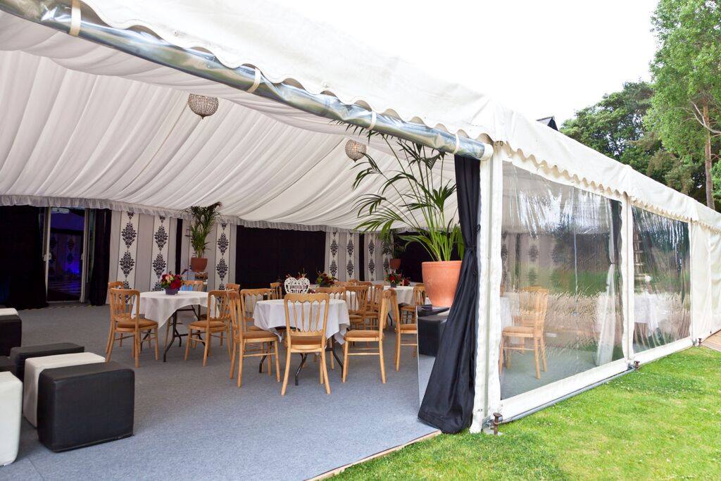A large white tent with tables and chairs inside of it