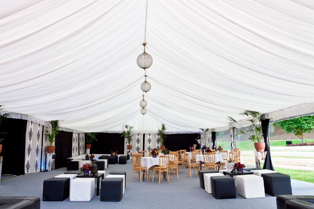 A large white tent with tables and chairs underneath it