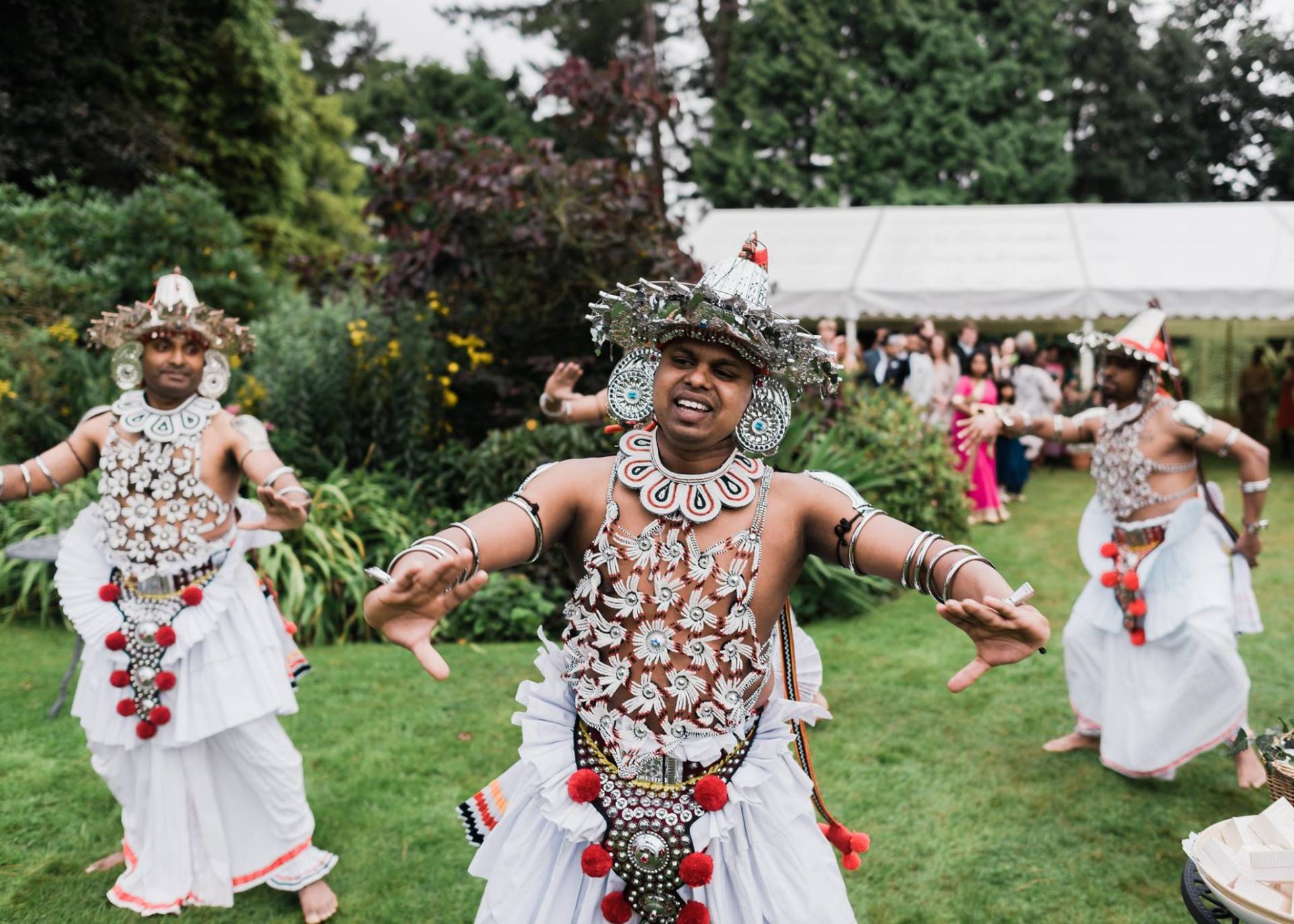 A group of men in traditional costumes are dancing in a field.