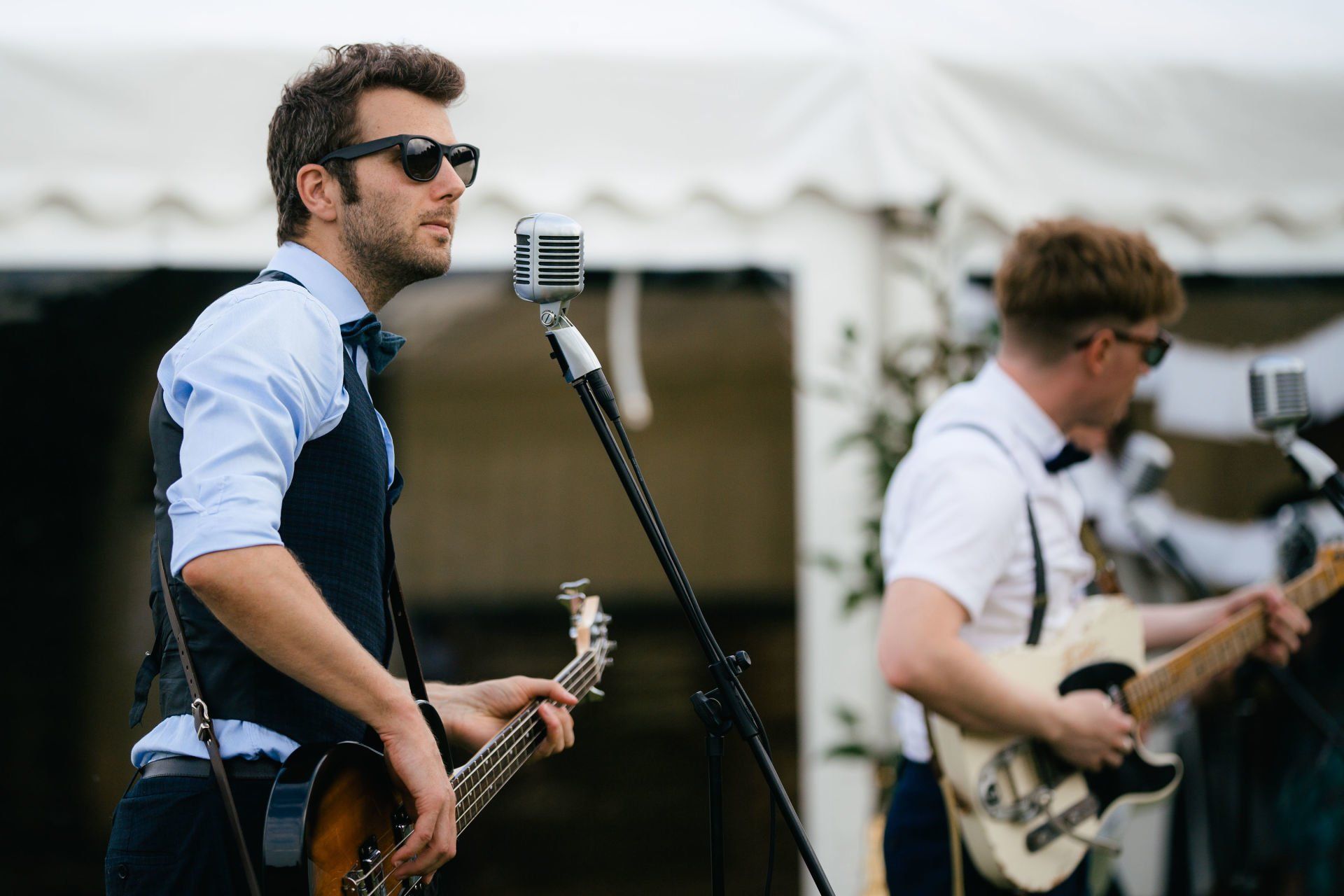 A man is playing a guitar and singing into a microphone.
