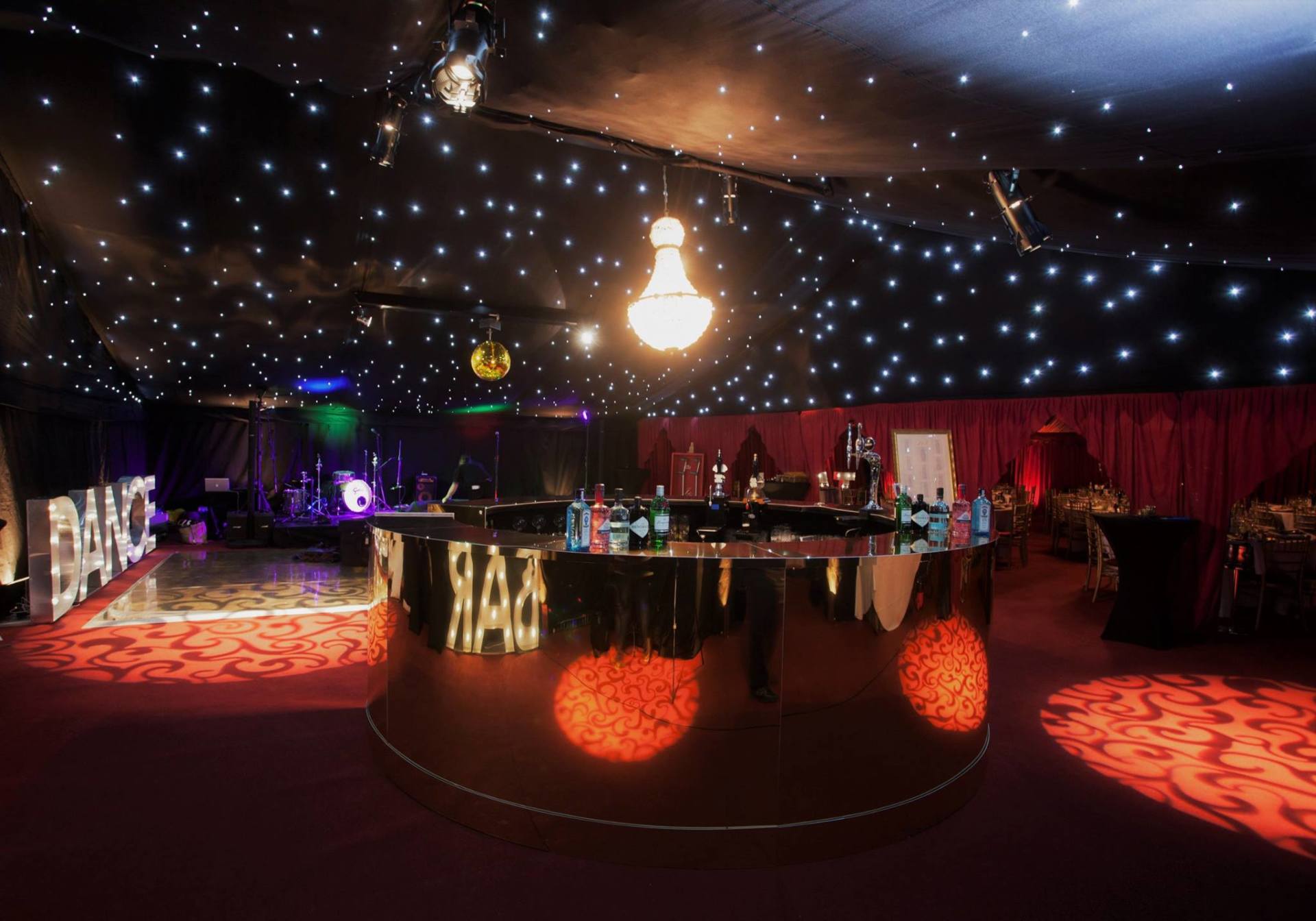 A large room with a dance floor and a chandelier hanging from the ceiling.