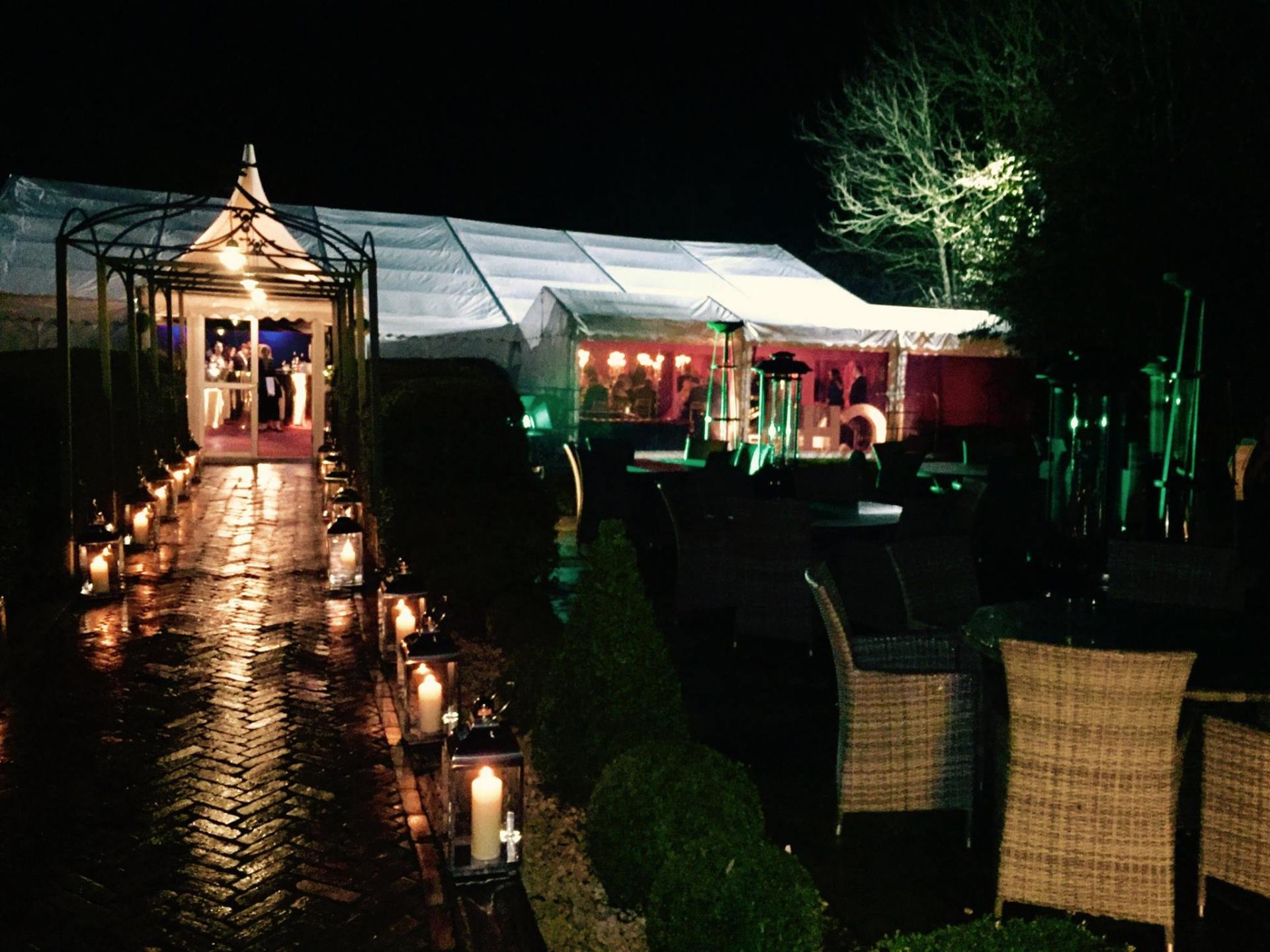 A row of lanterns are lined up in front of a tent at night