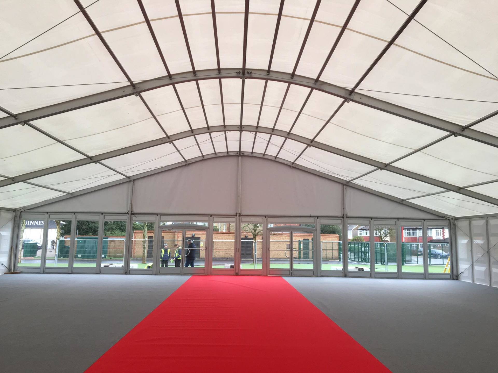 A large white tent with a red carpet leading to it
