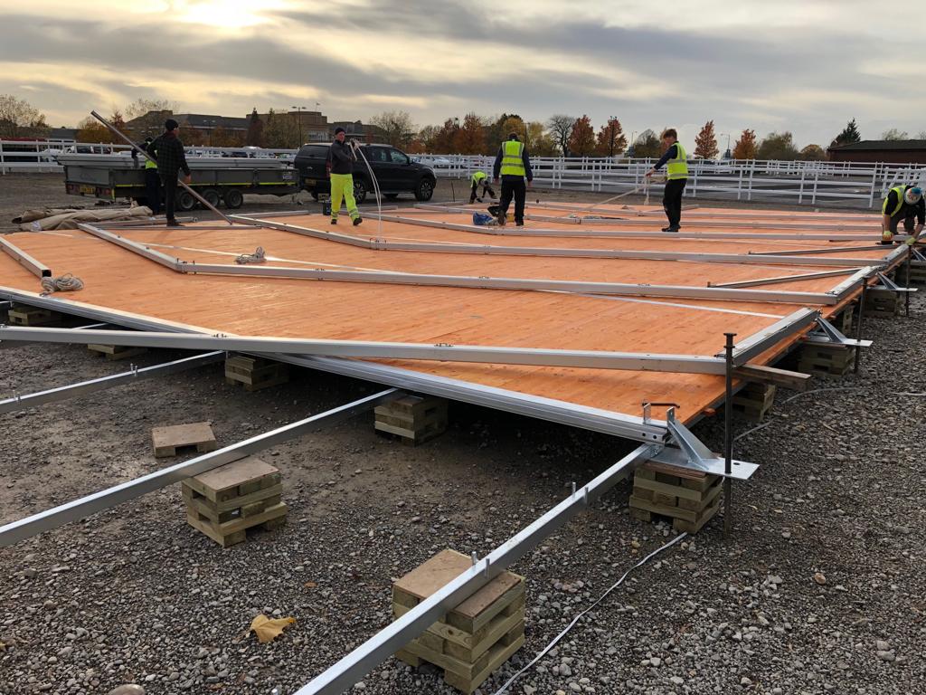 A group of construction workers are working on a large piece of wood.