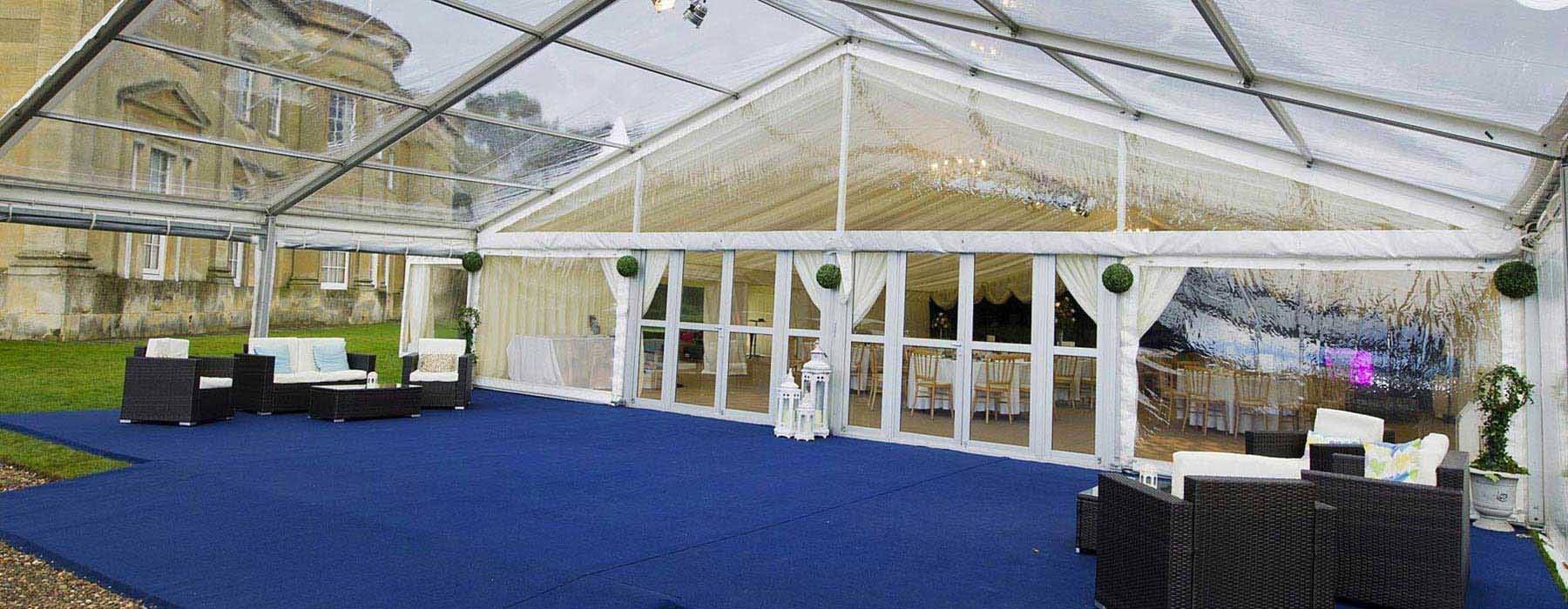 A clear tent is sitting on top of a blue carpet.