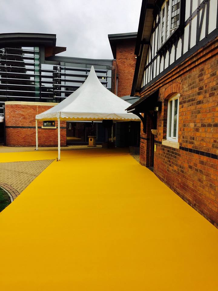 A white tent is sitting in front of a brick building.