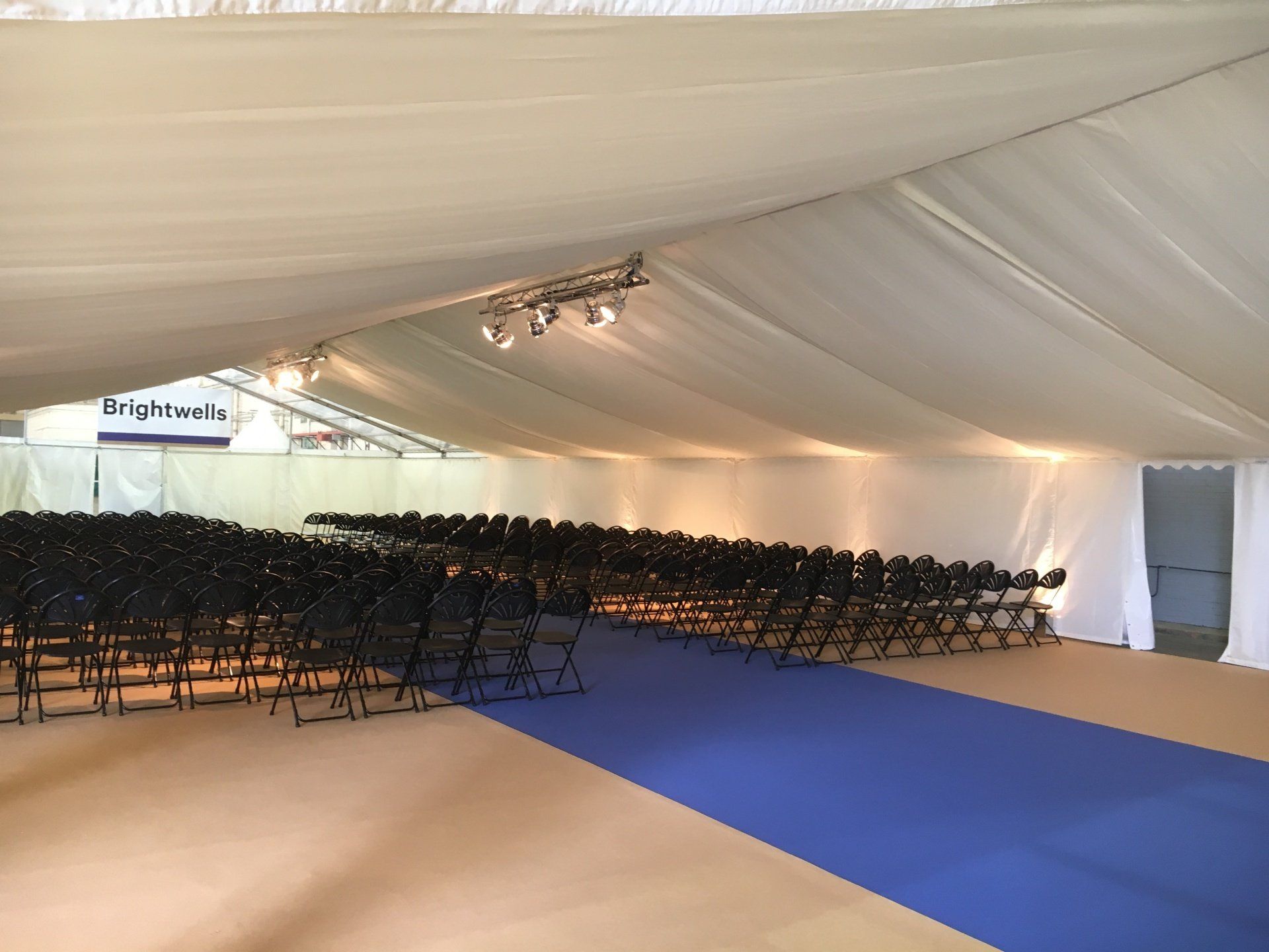 A large room with rows of chairs and a blue carpet.