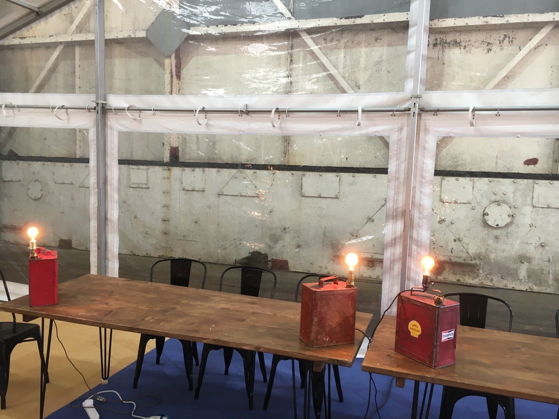 A room with tables and chairs and a clear roof.