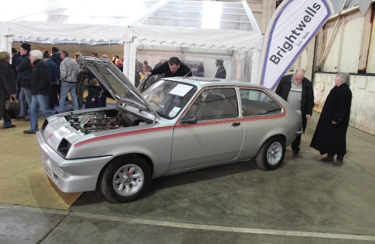 A silver car with the hood up and a banner that says brightwells