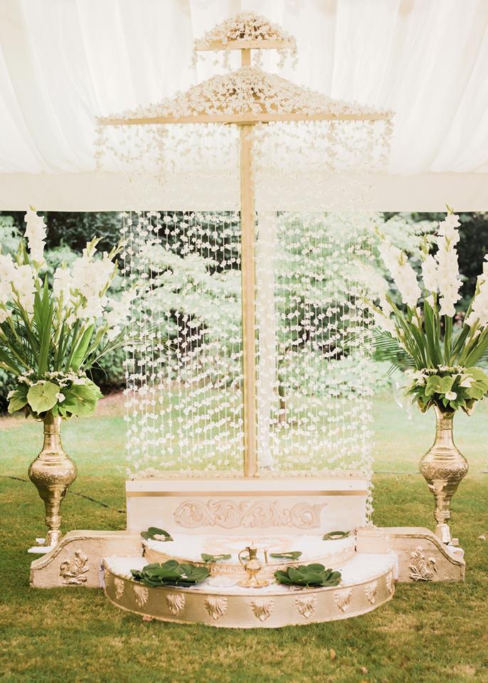 A white umbrella is sitting in the middle of a lush green field.