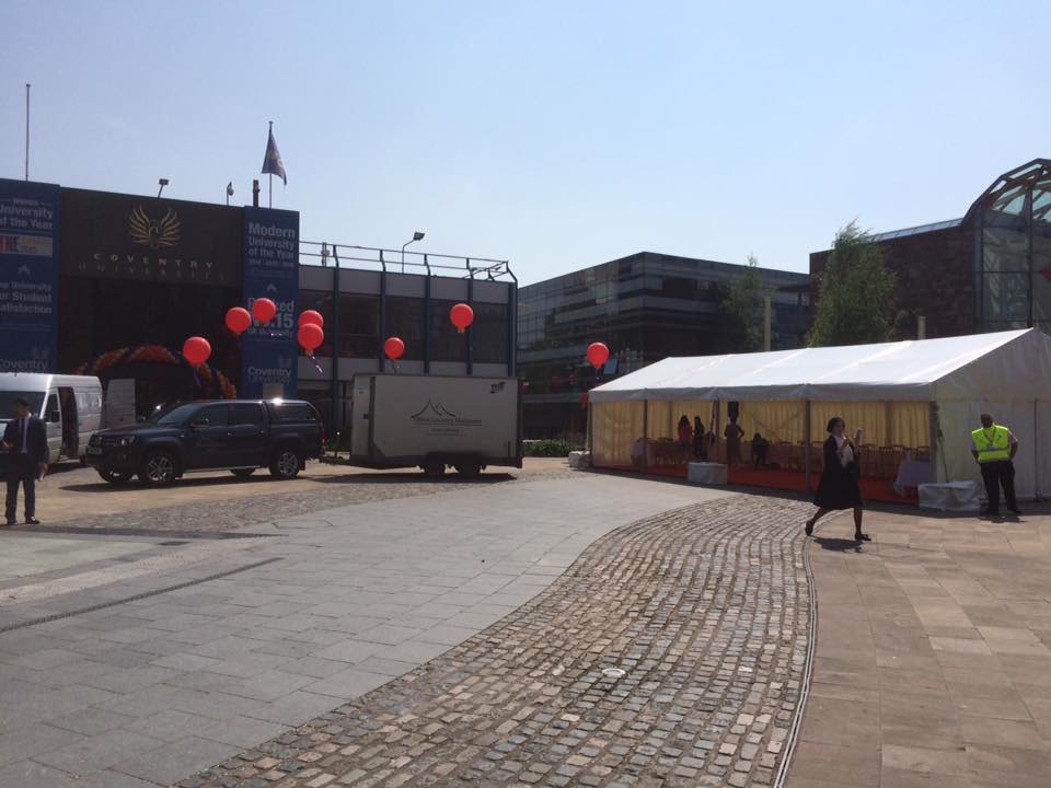 A white tent with red balloons on top of it