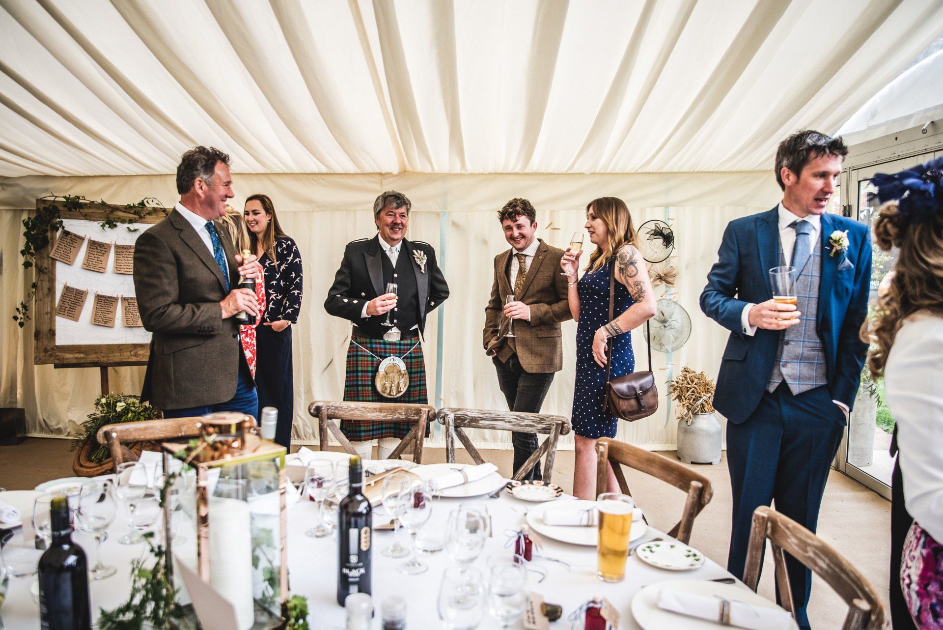 A group of people are standing around a table at a wedding reception.