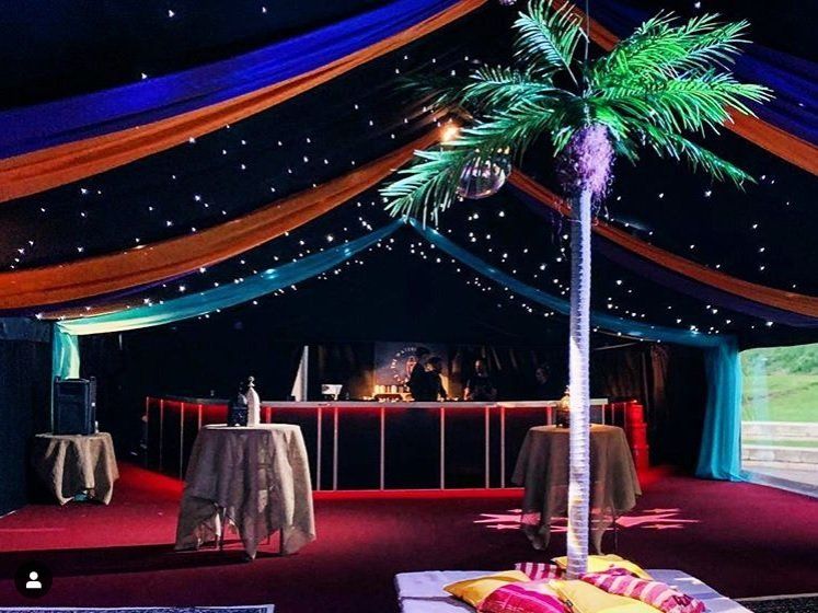 A large room with tables and a palm tree in the middle