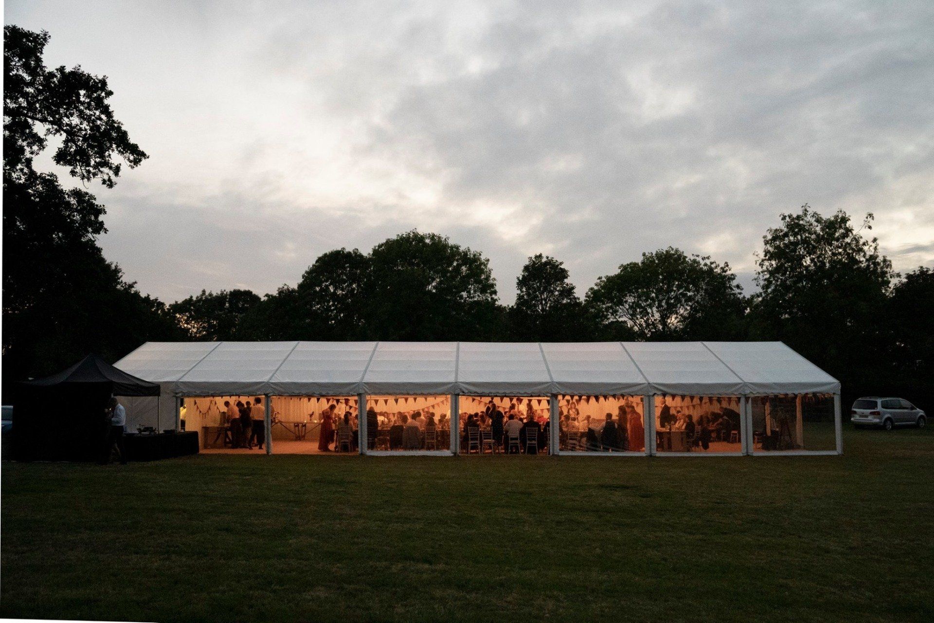A large white tent is sitting in the middle of a field