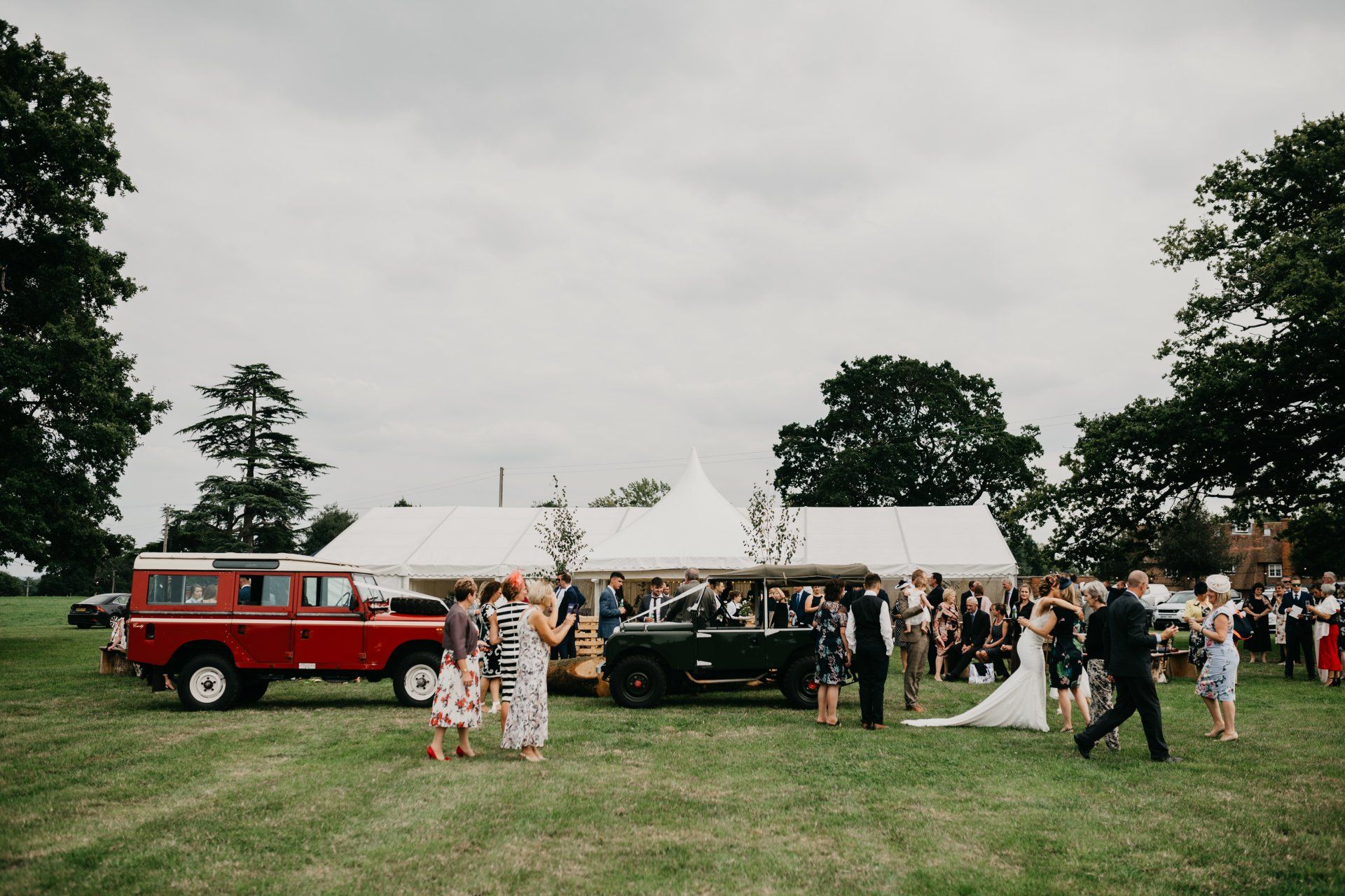 A group of people are standing in a field in front of a tent.