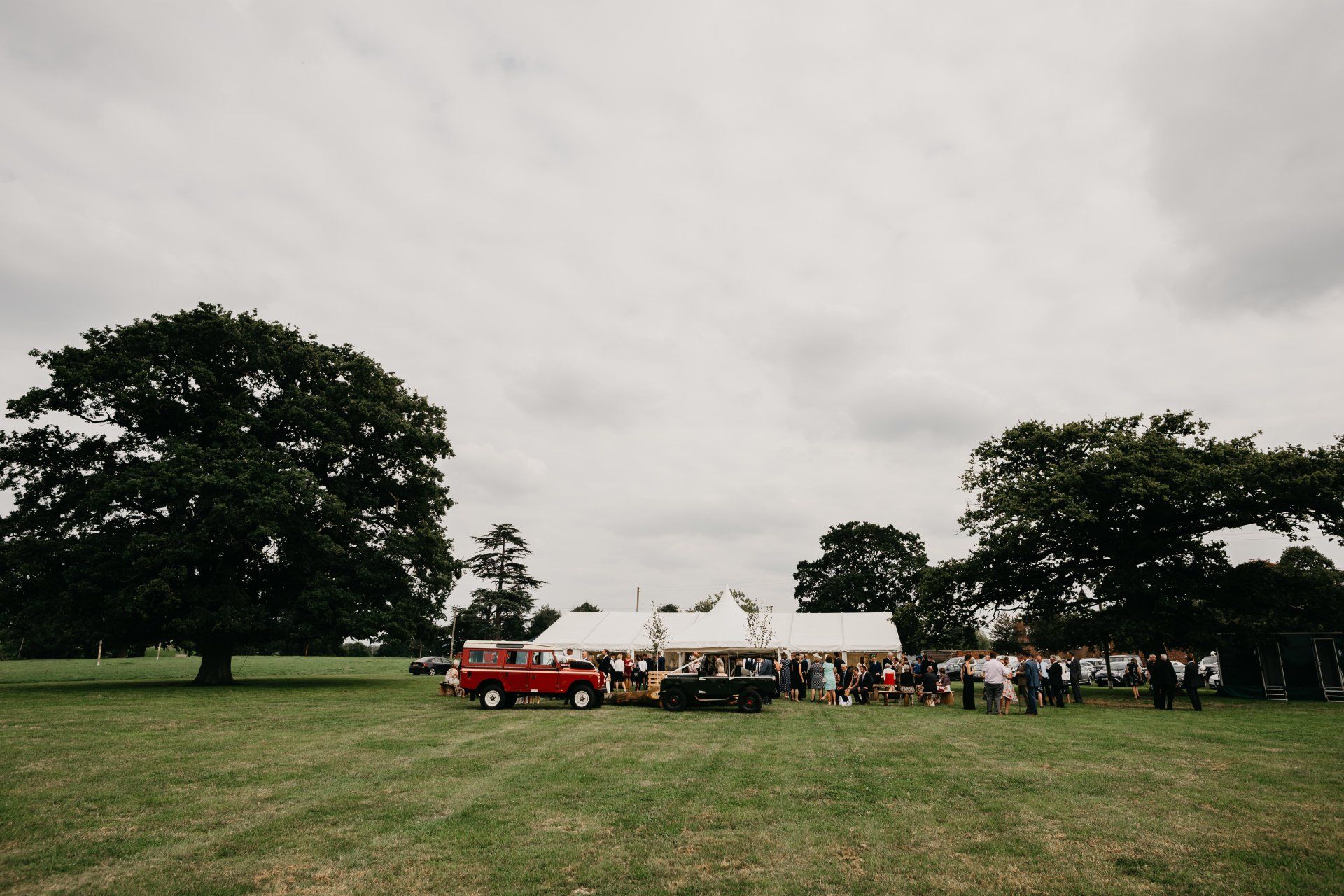 A group of people are standing in a field in front of a tent.