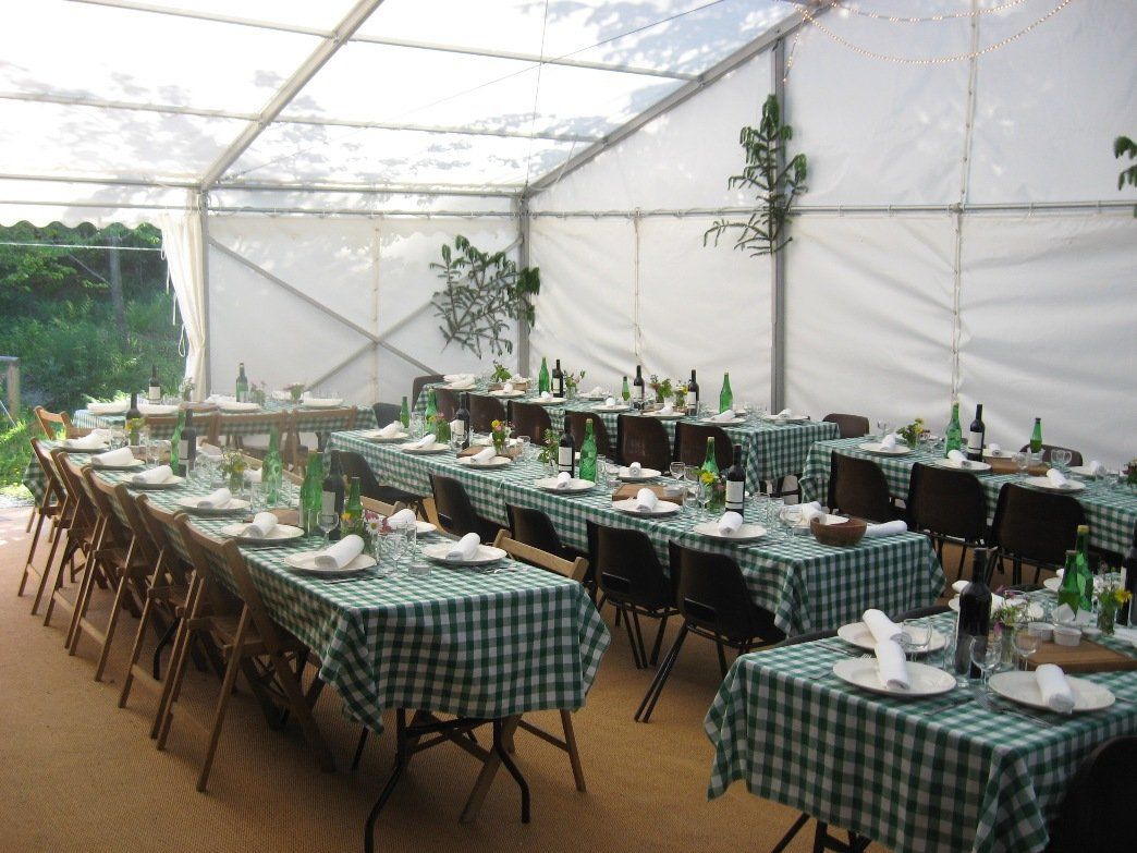 A tent with tables and chairs set up for a party