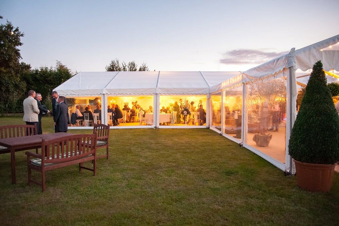 A group of people are standing outside of a tent.