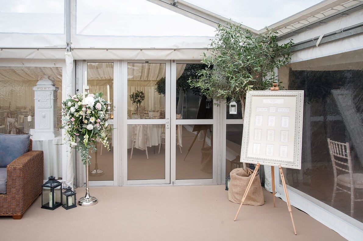 A large white tent with a table and chairs inside of it.