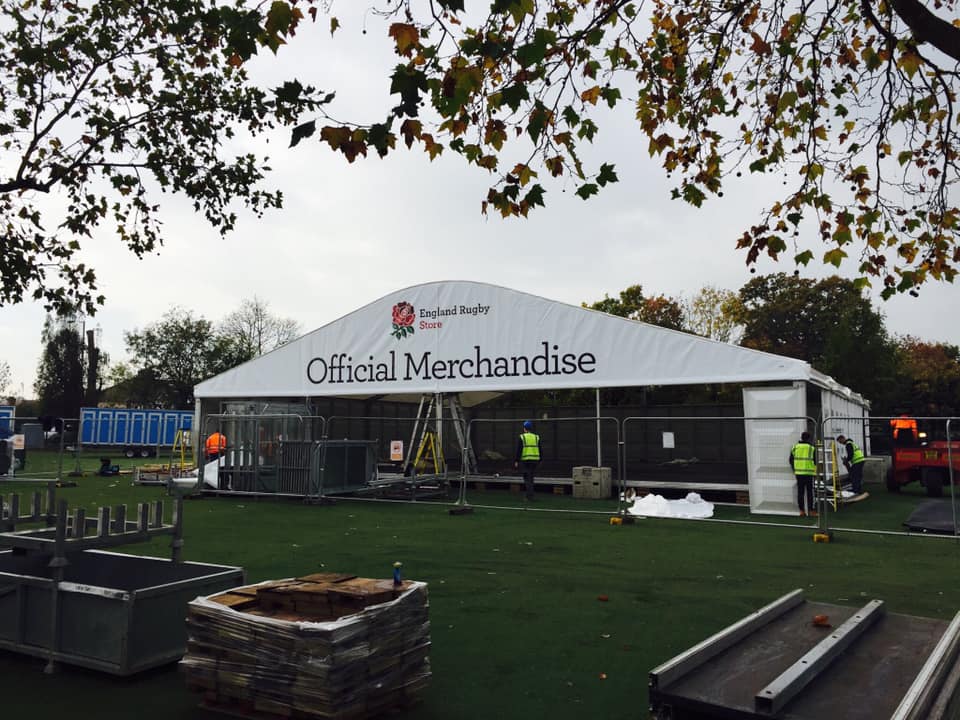 A large white tent with the words official merchandise on it