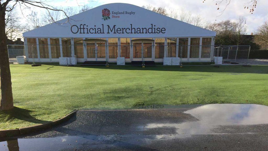 A large white tent is sitting in the middle of a grassy field.