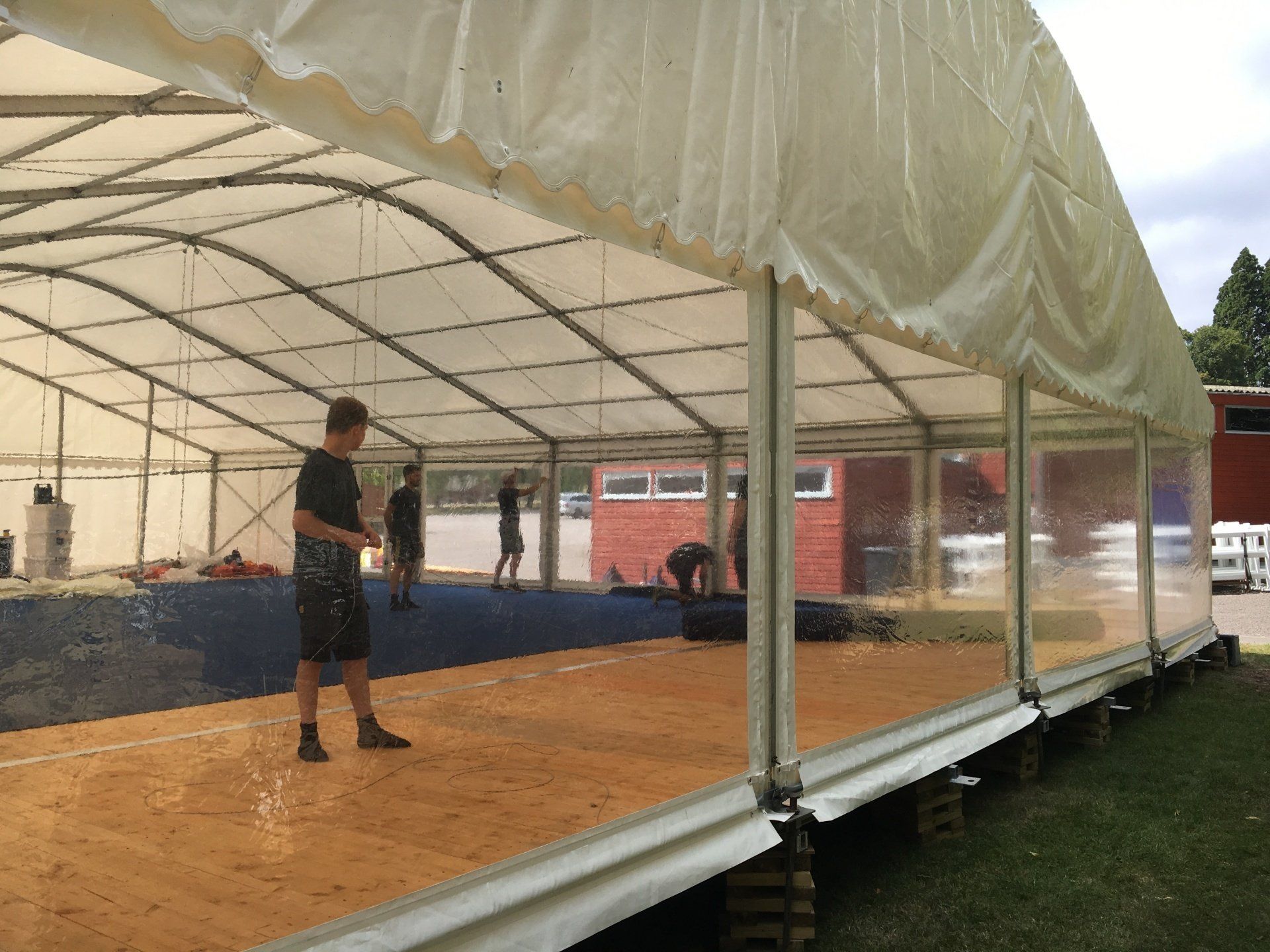 A man is standing in the middle of a large tent.
