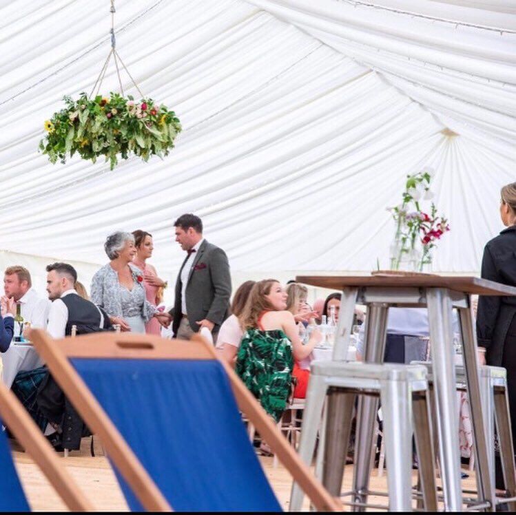 A group of people are sitting at tables in a tent.