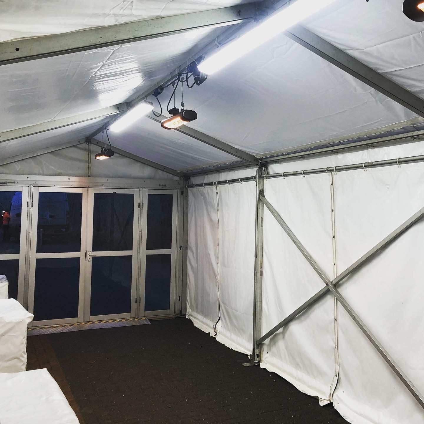 A large white tent with lights hanging from the ceiling