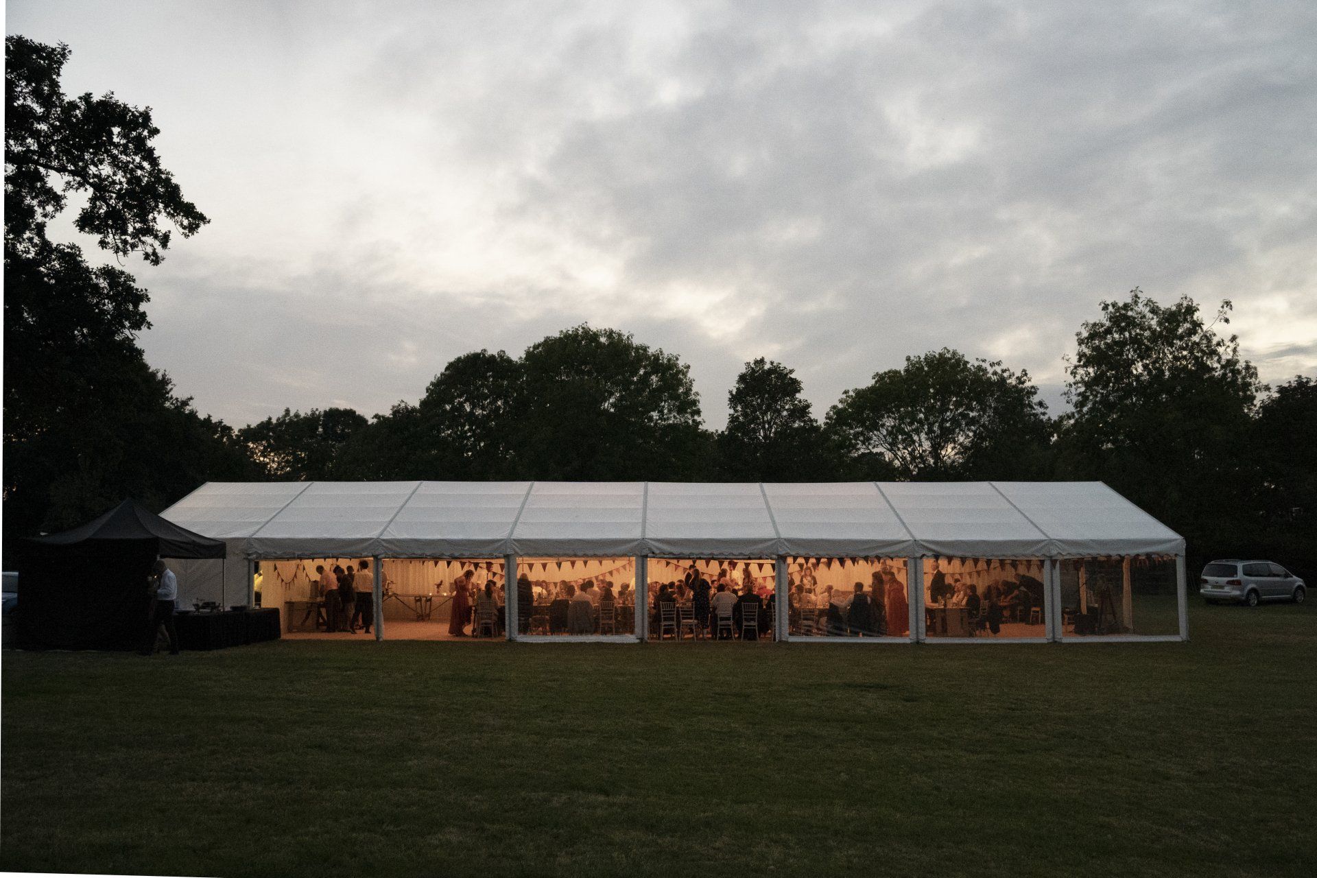 A large white tent is sitting in the middle of a field