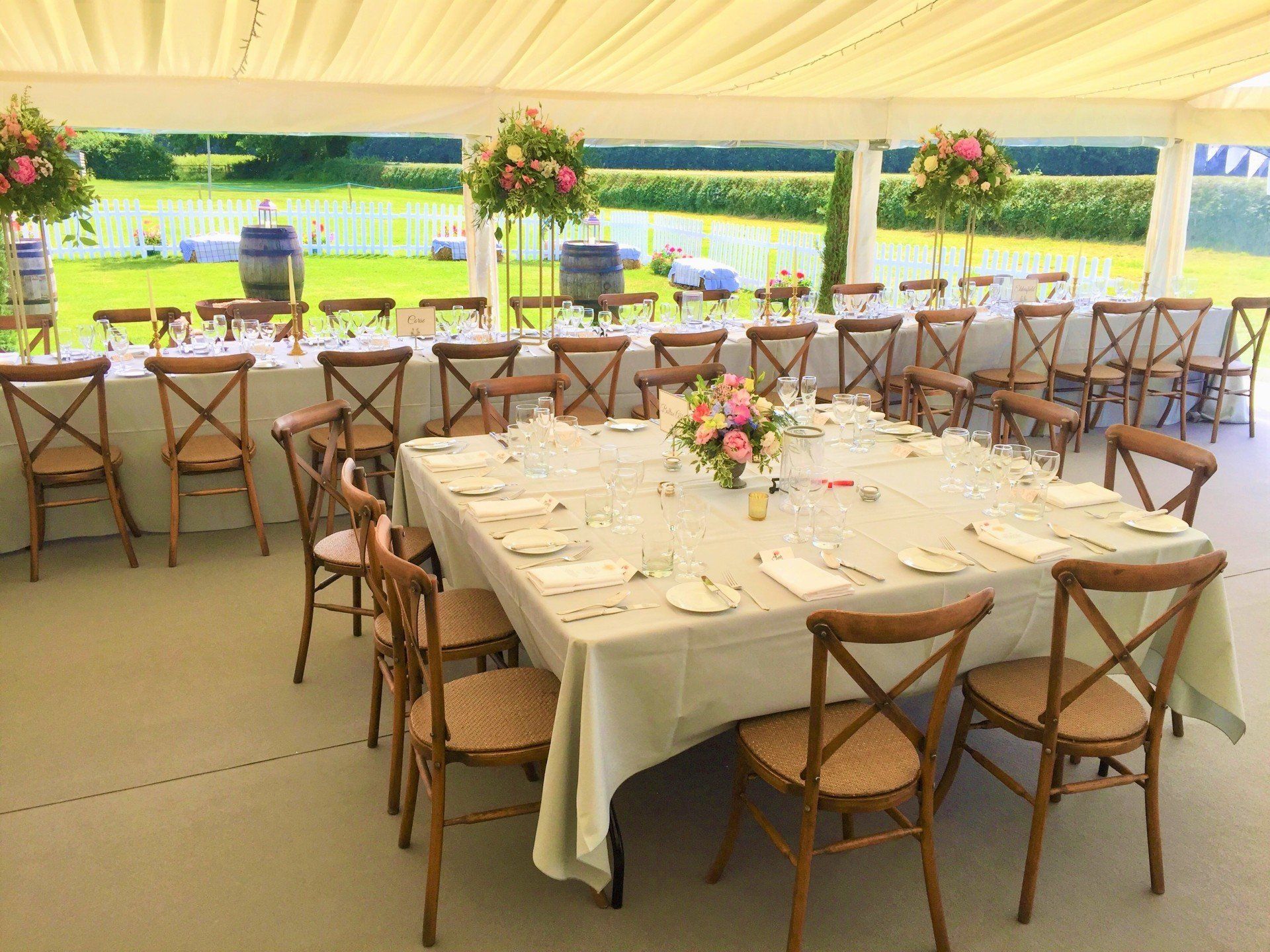A large tent with tables and chairs set up for a wedding reception.