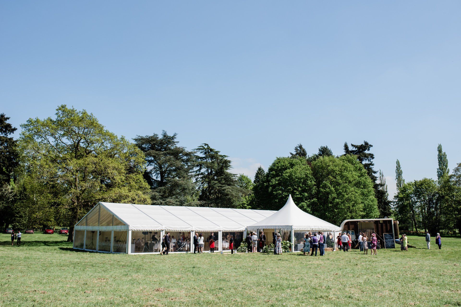A large white tent is sitting in the middle of a grassy field.