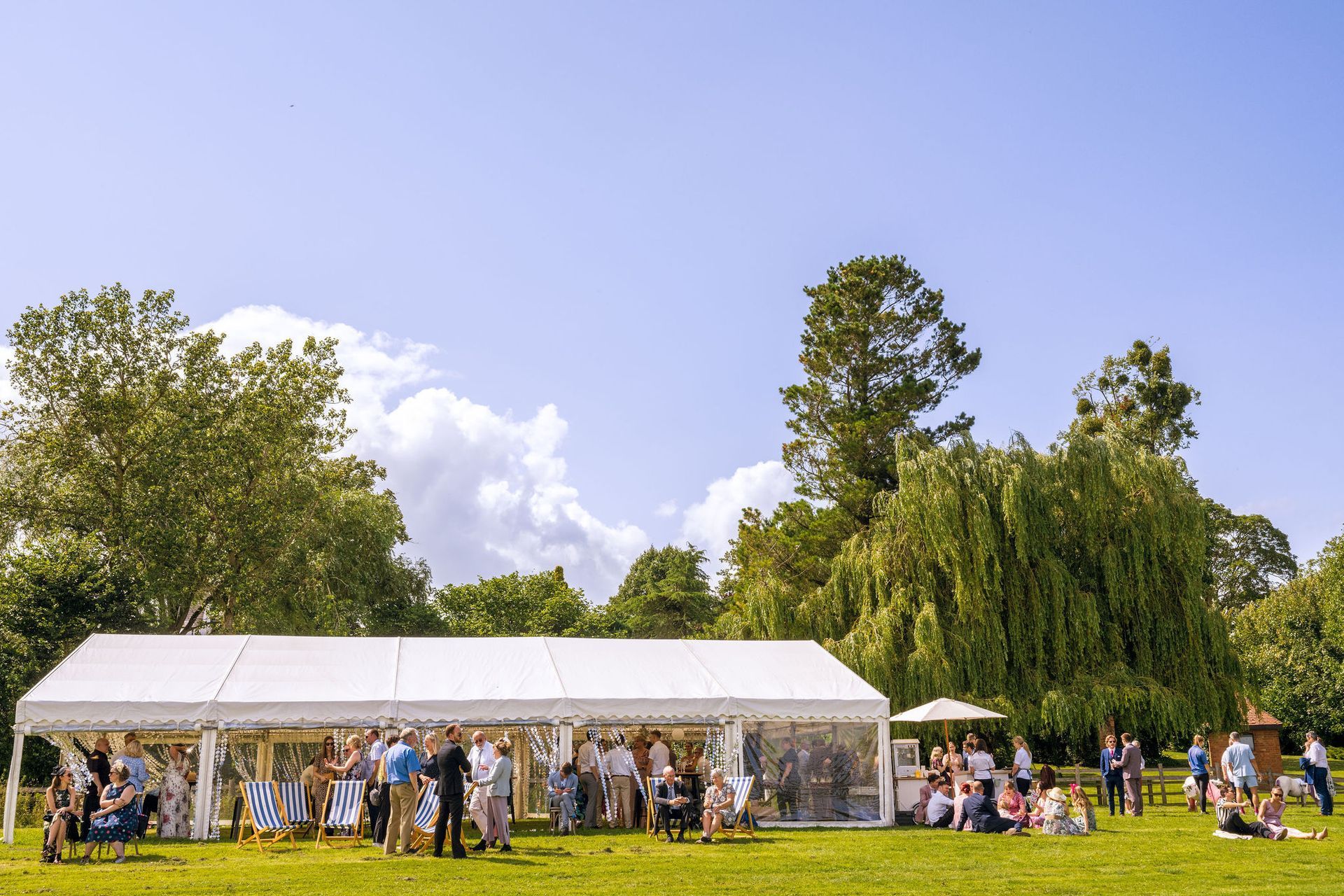 A large white tent is sitting in the middle of a grassy field.