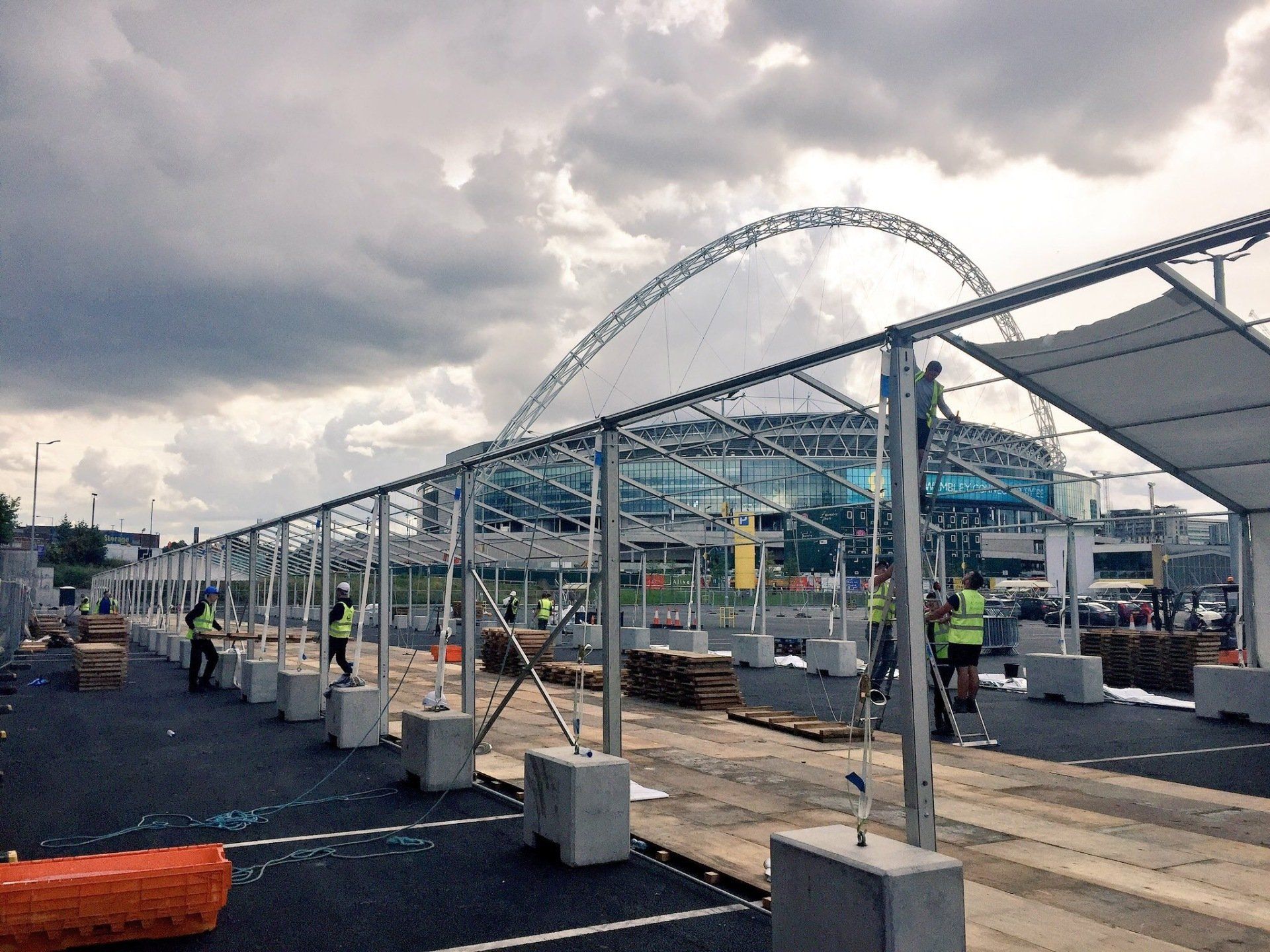 A group of people are working on a large structure in a parking lot.