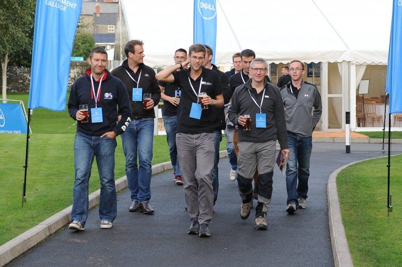 A group of men are walking down a road with flags that say dell on them
