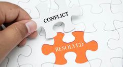 a person is holding a piece of a puzzle that says conflict and resolved