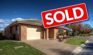 a house with a sold sign in front of it