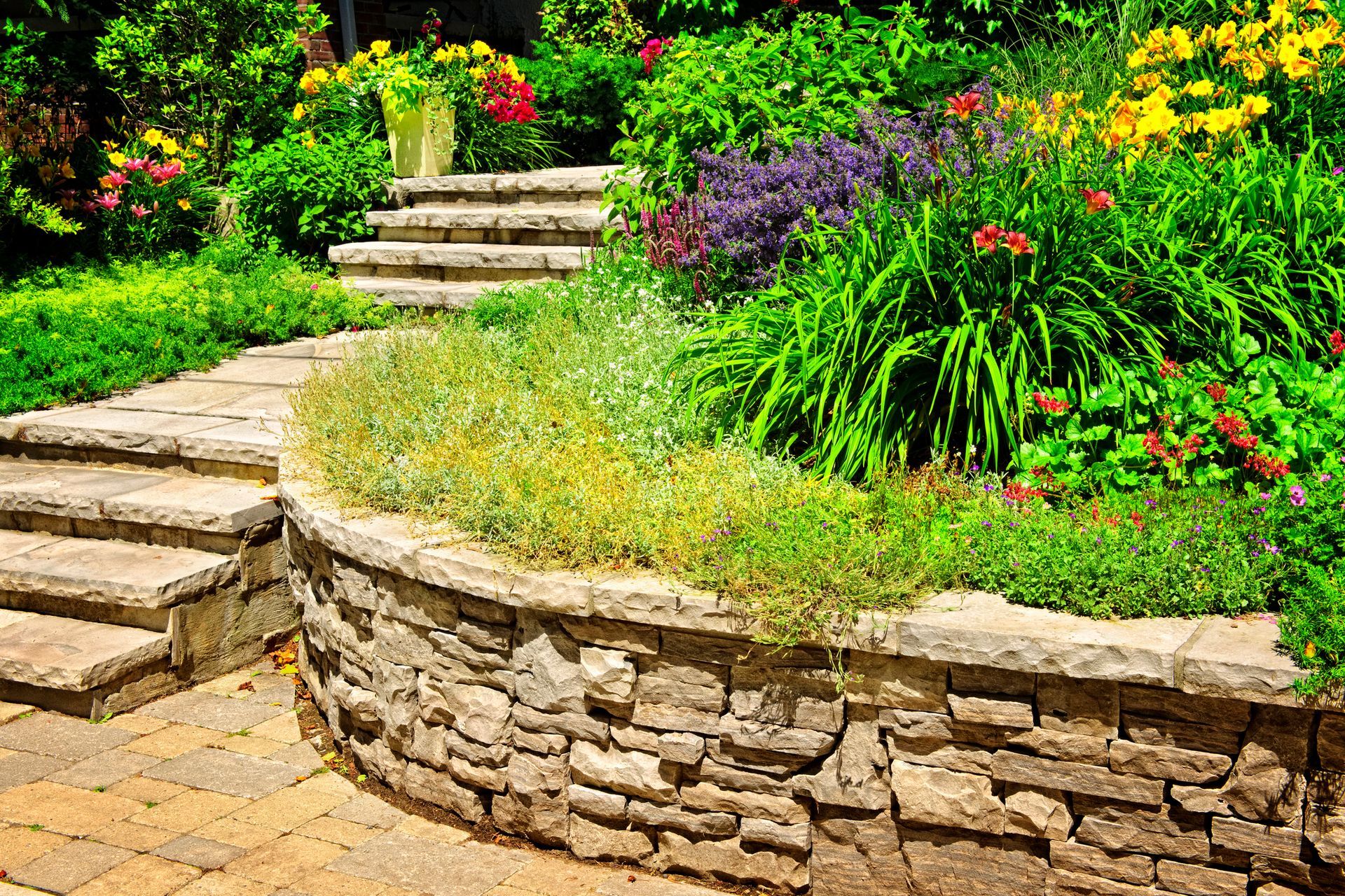 Stone retaining wall and vibrant garden steps showcasing landscaping ideas with Central Landscape Su