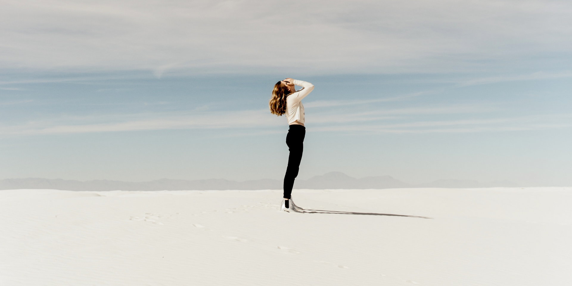 A blurry picture of a woman standing in front of a blue sky.